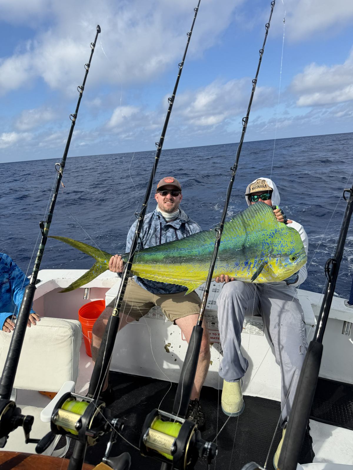 Happy anglers holding a large mahi-mahi catch aboard Conch Too Charters in Key West